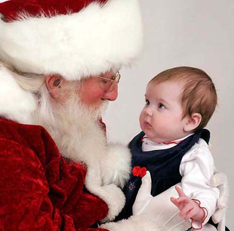 This young child shows no fear as she checks Santa out, eye-to-eye and up close